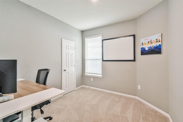 home office with light colored carpet and baseboards