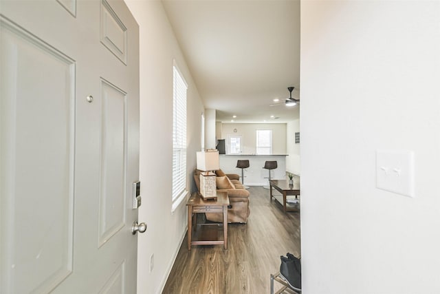 corridor with baseboards and wood finished floors