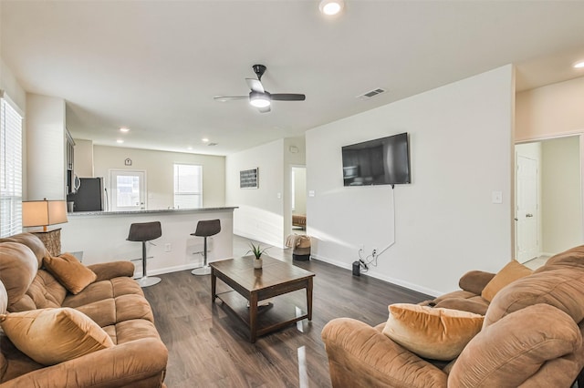 living room featuring dark wood finished floors, visible vents, and a healthy amount of sunlight