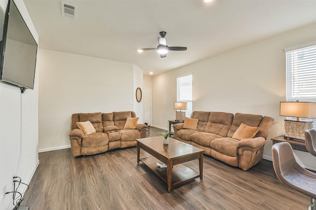 living room featuring dark wood-style floors, plenty of natural light, and visible vents