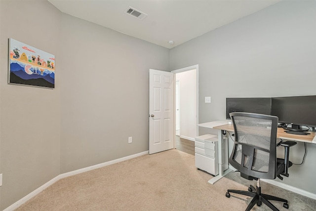 office space with baseboards, visible vents, and light colored carpet