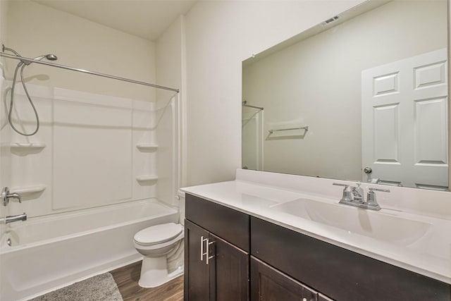 full bath featuring toilet, wood finished floors, visible vents, vanity, and shower / washtub combination