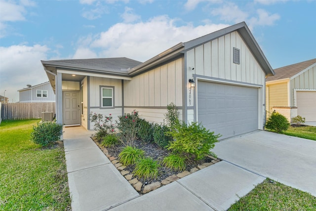 view of front facade featuring driveway, an attached garage, fence, cooling unit, and board and batten siding