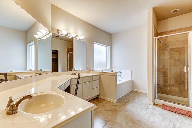 bathroom with double vanity, a garden tub, a sink, and a stall shower