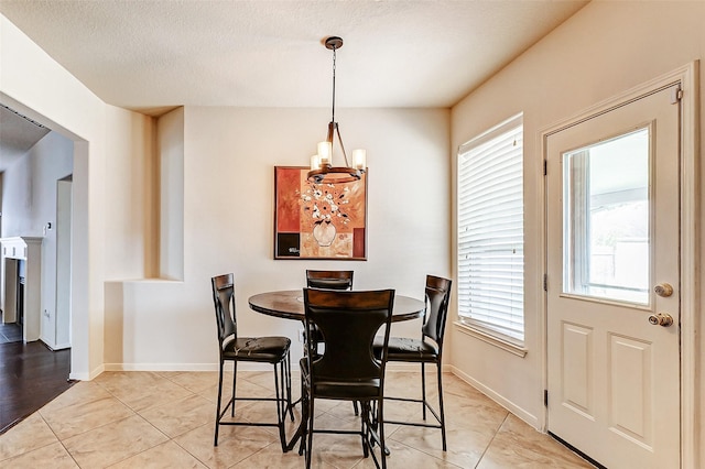 dining space with a wealth of natural light, a notable chandelier, and light tile patterned floors