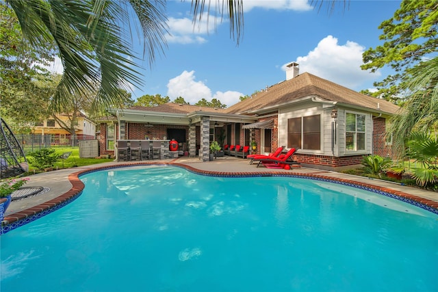 view of pool with a bar and a patio