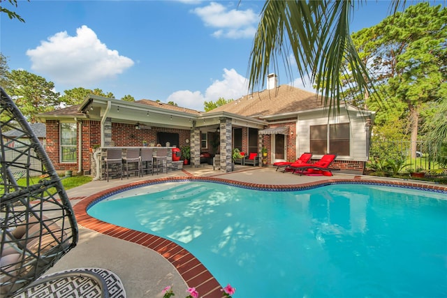 view of swimming pool with a patio and an outdoor bar