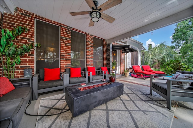 view of patio featuring ceiling fan and an outdoor living space with a fire pit