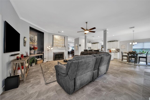 living room featuring ceiling fan with notable chandelier and crown molding