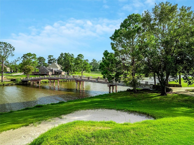 view of property's community featuring a yard and a water view