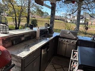 view of patio / terrace featuring exterior kitchen, sink, and grilling area