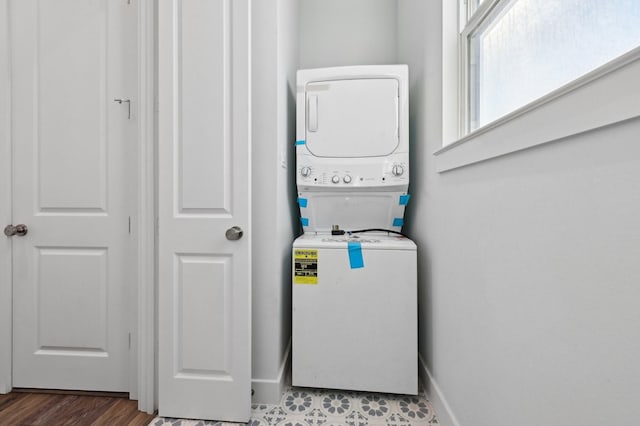 clothes washing area with stacked washer and clothes dryer