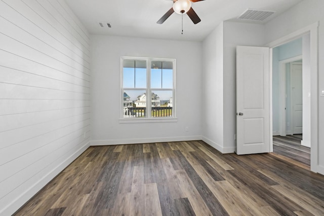 unfurnished room with ceiling fan and dark hardwood / wood-style flooring