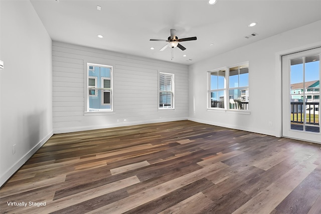 spare room featuring ceiling fan, a healthy amount of sunlight, and dark hardwood / wood-style floors