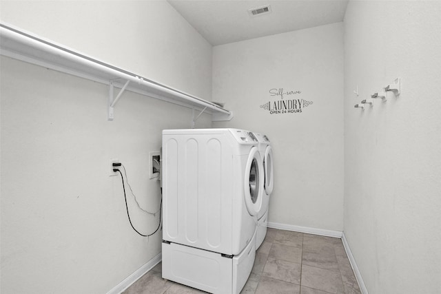 laundry room featuring light tile patterned floors and separate washer and dryer