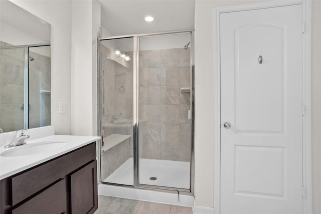 bathroom featuring tile patterned flooring, vanity, and walk in shower