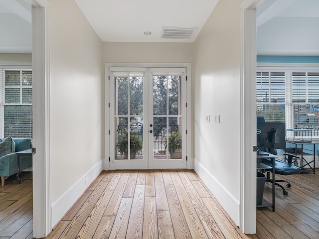 doorway with french doors and light hardwood / wood-style flooring