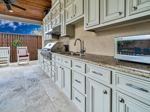 kitchen featuring ceiling fan, sink, cream cabinets, stone countertops, and wooden ceiling