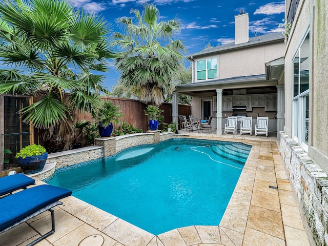 view of swimming pool with a patio area and exterior kitchen