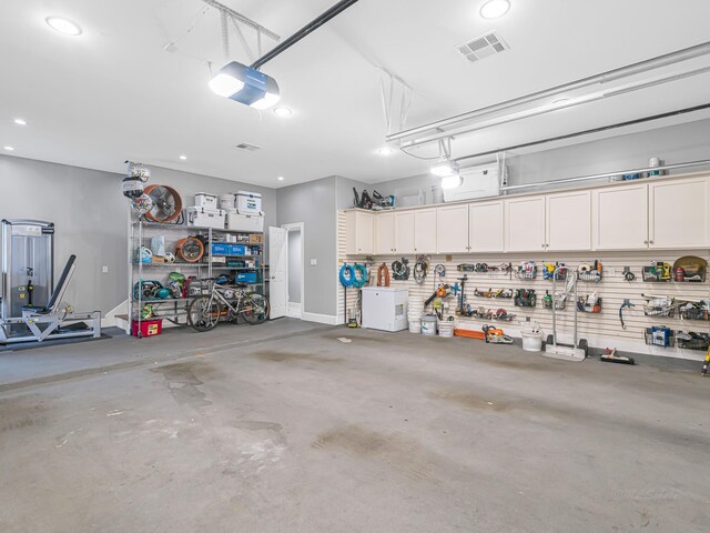 garage with a workshop area and a garage door opener