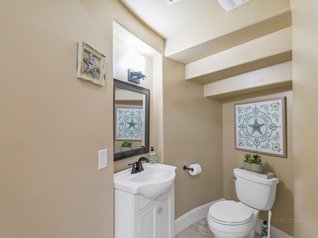 bathroom with tile patterned flooring, vanity, and toilet