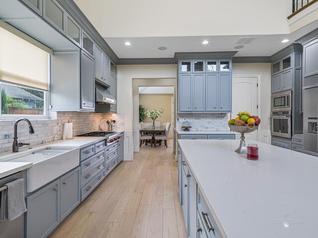 kitchen featuring appliances with stainless steel finishes, tasteful backsplash, crown molding, and sink