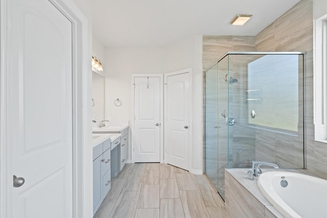 bathroom with vanity and shower with separate bathtub