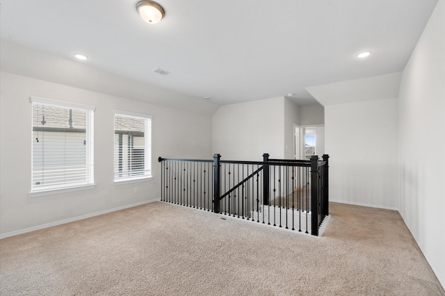 interior space featuring light carpet and vaulted ceiling