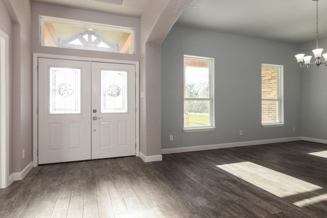 entryway with dark hardwood / wood-style flooring, french doors, and an inviting chandelier