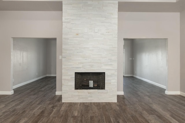 unfurnished living room featuring a fireplace and dark wood-type flooring