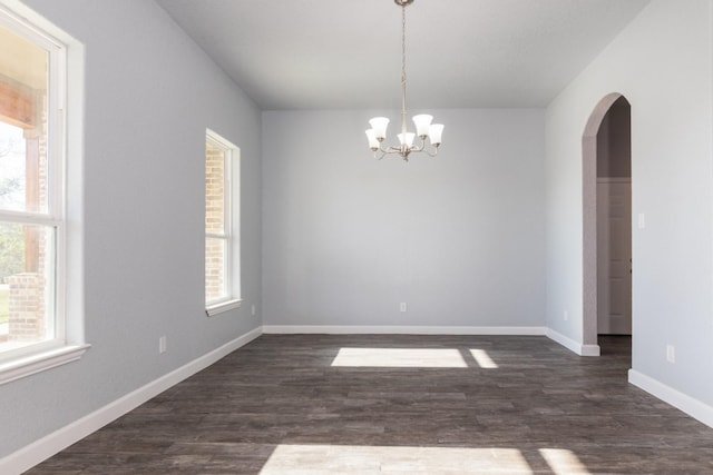 unfurnished room featuring dark hardwood / wood-style flooring and a chandelier