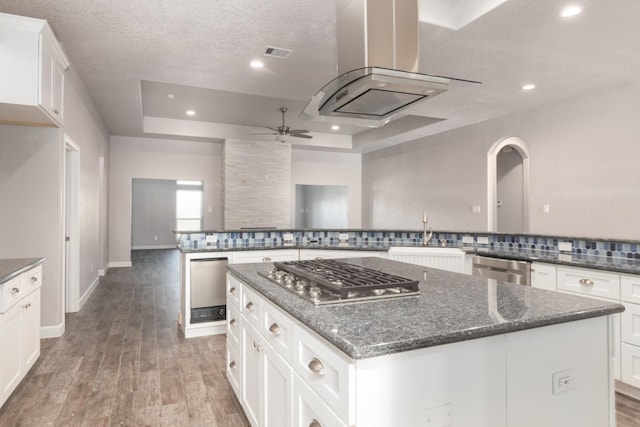 kitchen featuring a spacious island, sink, appliances with stainless steel finishes, tasteful backsplash, and dark hardwood / wood-style flooring