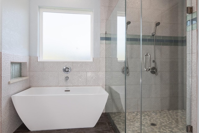 bathroom with tile walls and plus walk in shower