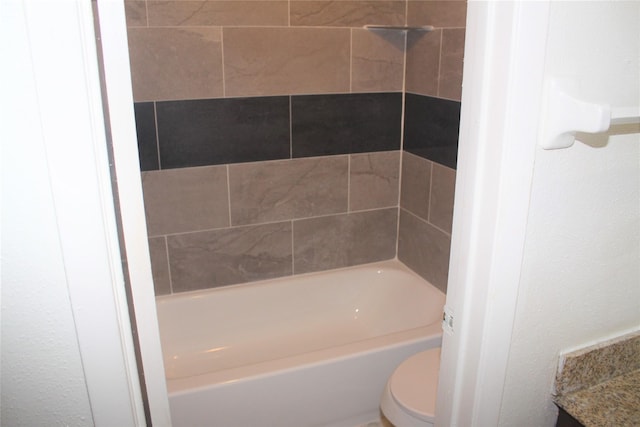 full bathroom with tiled shower / bath combo, toilet, and vanity