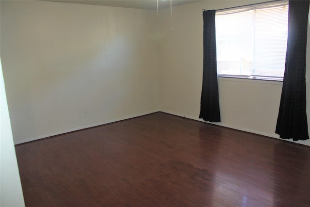 spare room with dark hardwood / wood-style floors