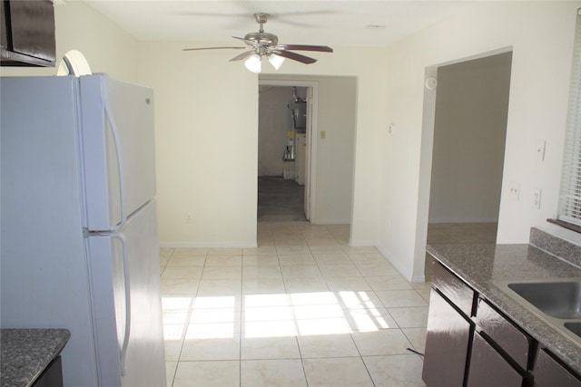 kitchen featuring ceiling fan, sink, white fridge, dark brown cabinets, and light tile patterned flooring