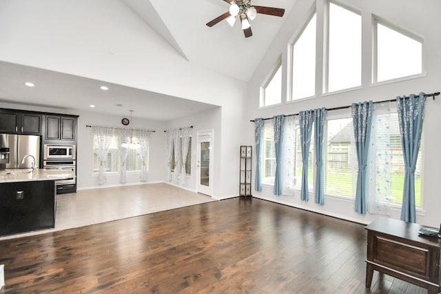 living room featuring ceiling fan, dark hardwood / wood-style flooring, and high vaulted ceiling