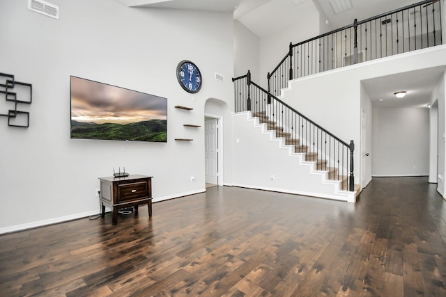 living room with high vaulted ceiling and dark wood-type flooring