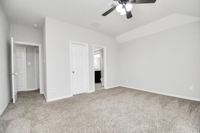 unfurnished bedroom with ceiling fan, light colored carpet, lofted ceiling, and connected bathroom