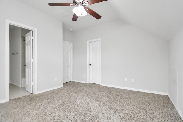 unfurnished bedroom featuring ceiling fan, light colored carpet, connected bathroom, and vaulted ceiling