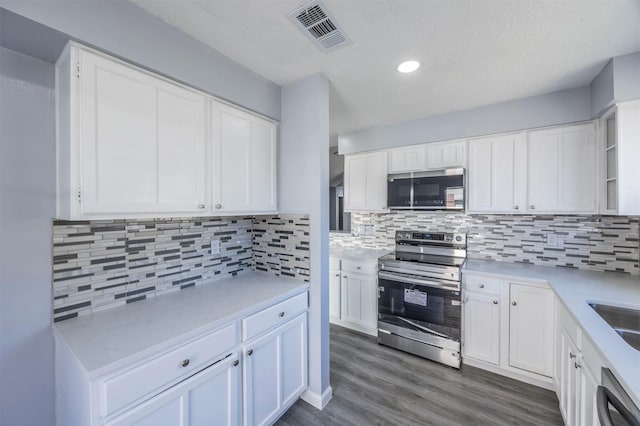 kitchen featuring electric range, dark hardwood / wood-style floors, white cabinets, and dishwasher