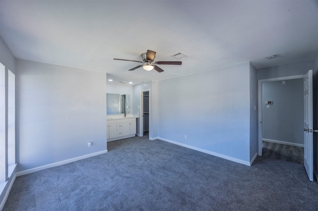 unfurnished bedroom featuring a walk in closet, ceiling fan, dark colored carpet, connected bathroom, and a closet