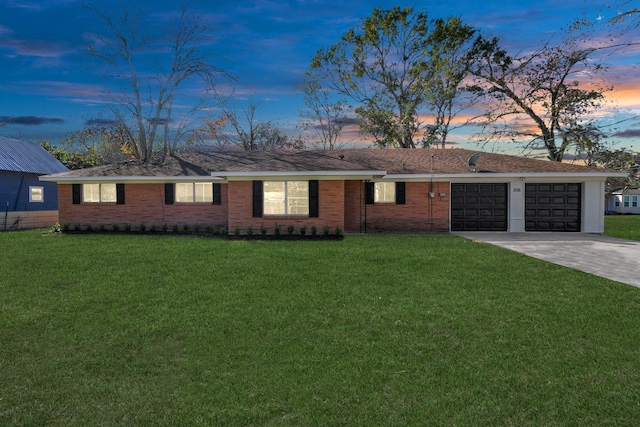 ranch-style house featuring a garage and a lawn