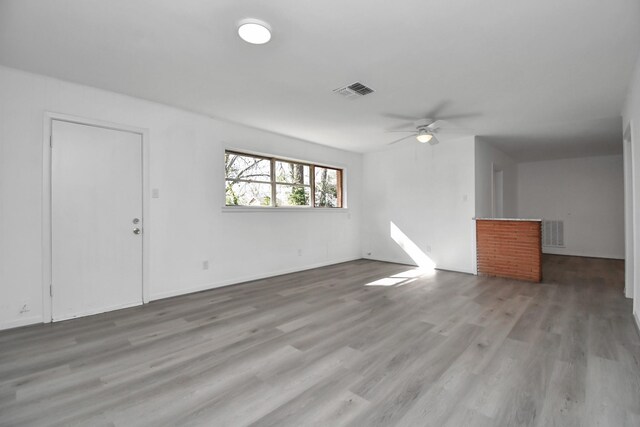 unfurnished living room featuring ceiling fan and hardwood / wood-style flooring