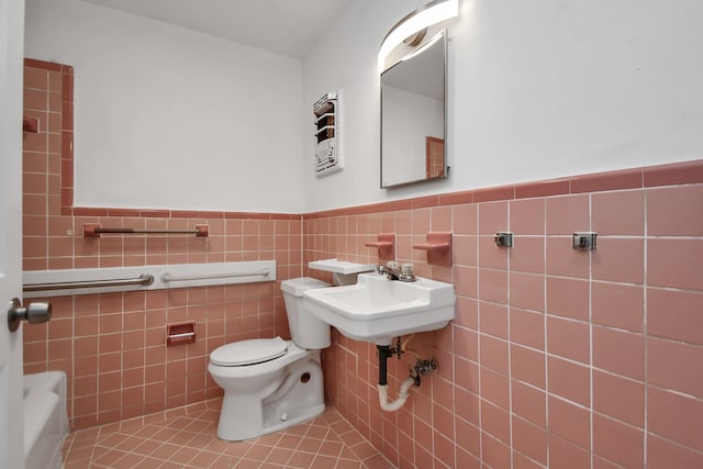 bathroom featuring tile patterned flooring, toilet, and tile walls