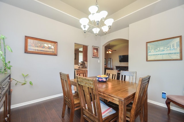 dining area featuring ceiling fan with notable chandelier and dark hardwood / wood-style flooring