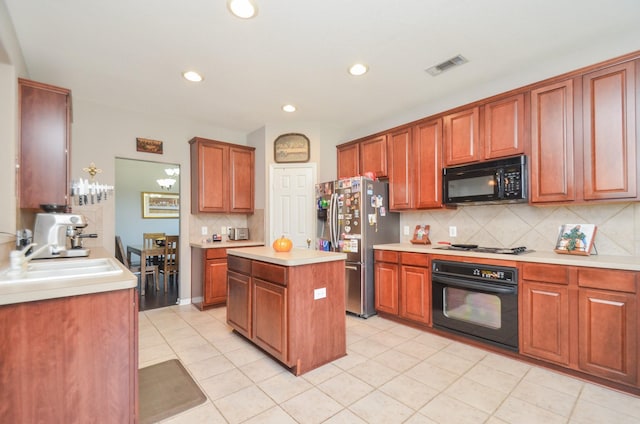 kitchen with light tile patterned flooring, black appliances, sink, tasteful backsplash, and a kitchen island