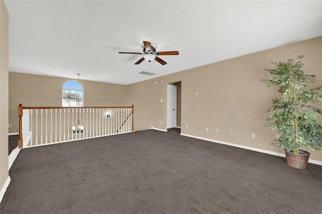 empty room with ceiling fan and dark colored carpet