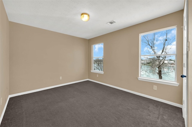 unfurnished room featuring dark colored carpet