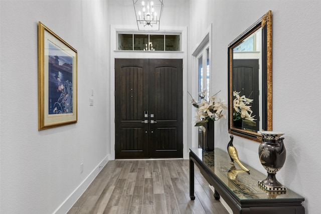 foyer entrance with hardwood / wood-style flooring and a notable chandelier